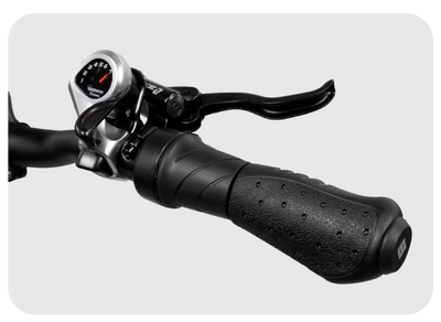 Close-up of a bicycle handlebar with a black rubber grip. Attached are a brake lever and a gear shifter, which has an indicator showing the current gear. This XP 3.0 Long-Range eBike is designed to help you explore further, with the background kept plain to highlight its components.