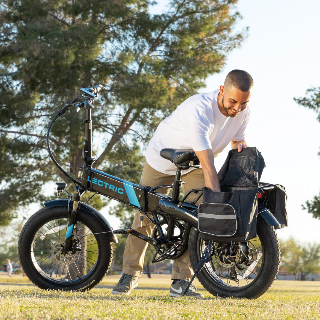 A man reaches into the pannier bag on the back of his Lectric XP 2.0