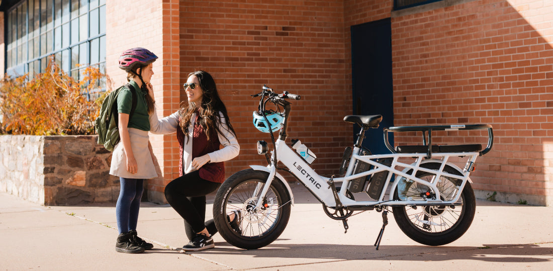 mother dropping off daughter at school with xpedition kneeling down with helmet